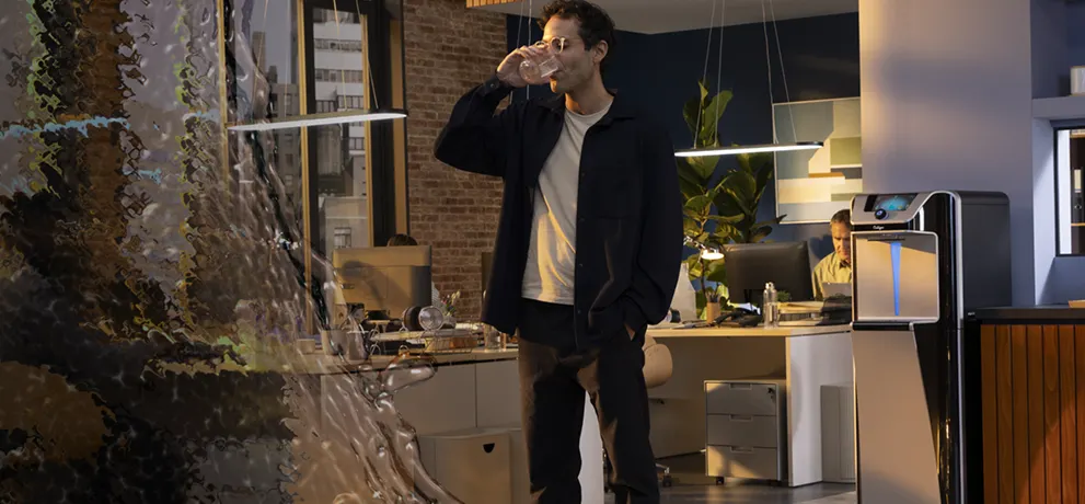 Persona sirviendo agua purificada desde dispensador Culligan en oficina moderna